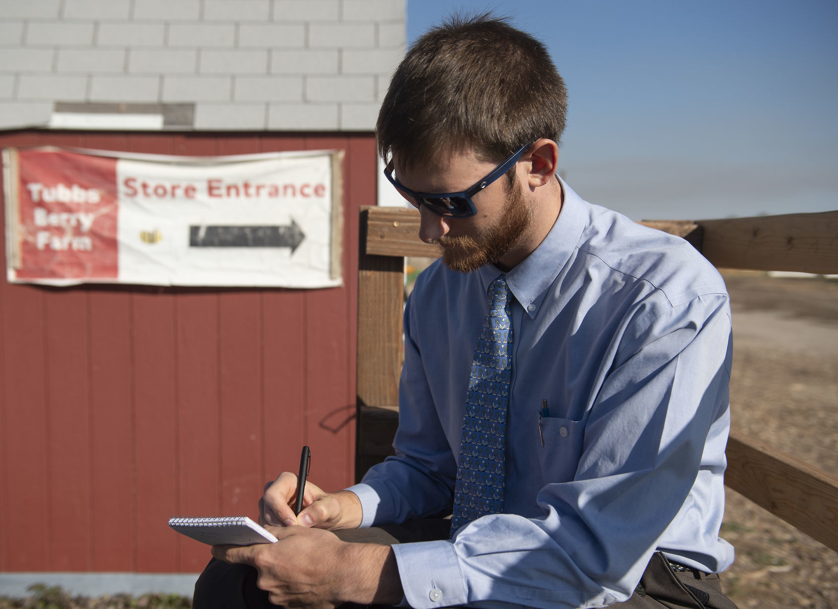 Reporter takes field notes in a field